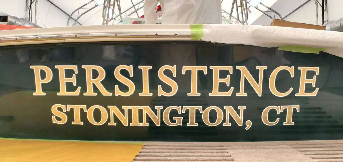 22K gold leaf boat name lettering on a green hull transom