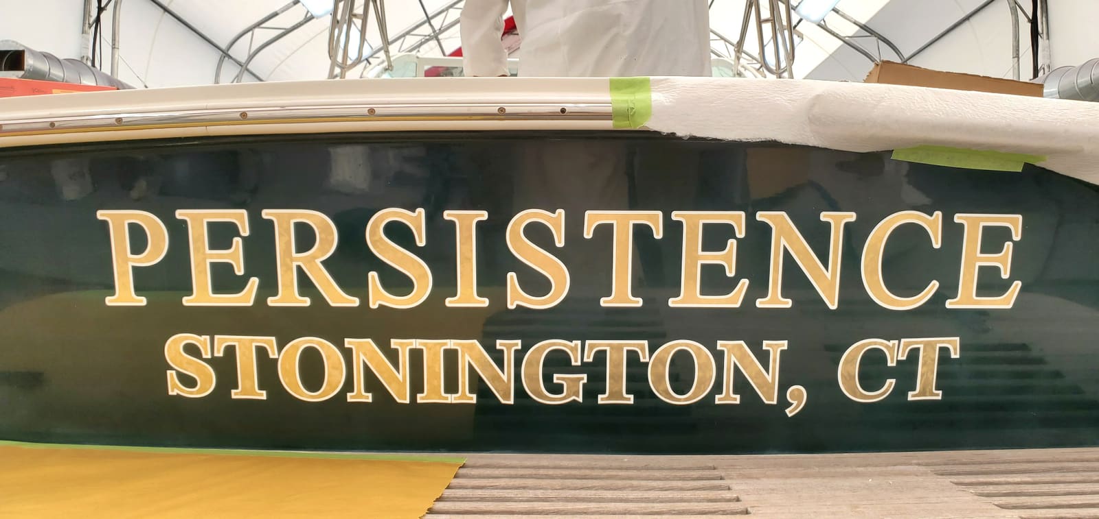 22K gold leaf boat name lettering on a green hull transom